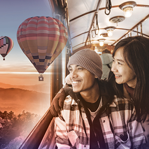 Two travelers on a train looking out the window
